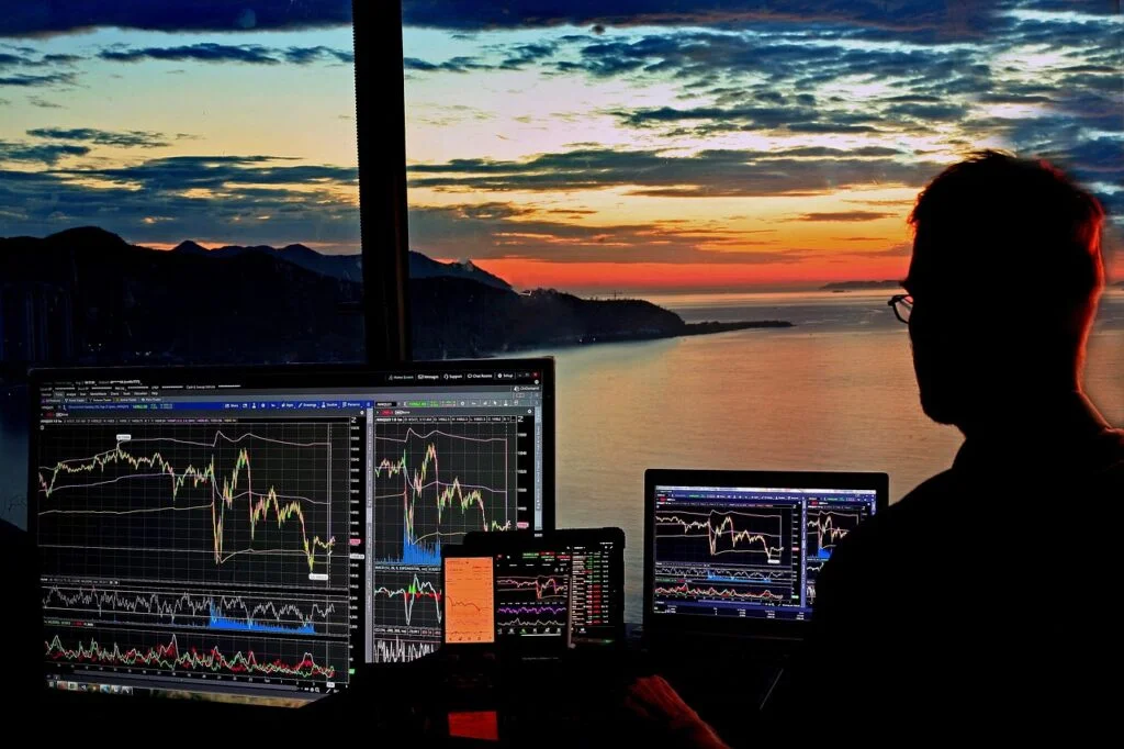 Pessoa analisando gráficos financeiros no monitor